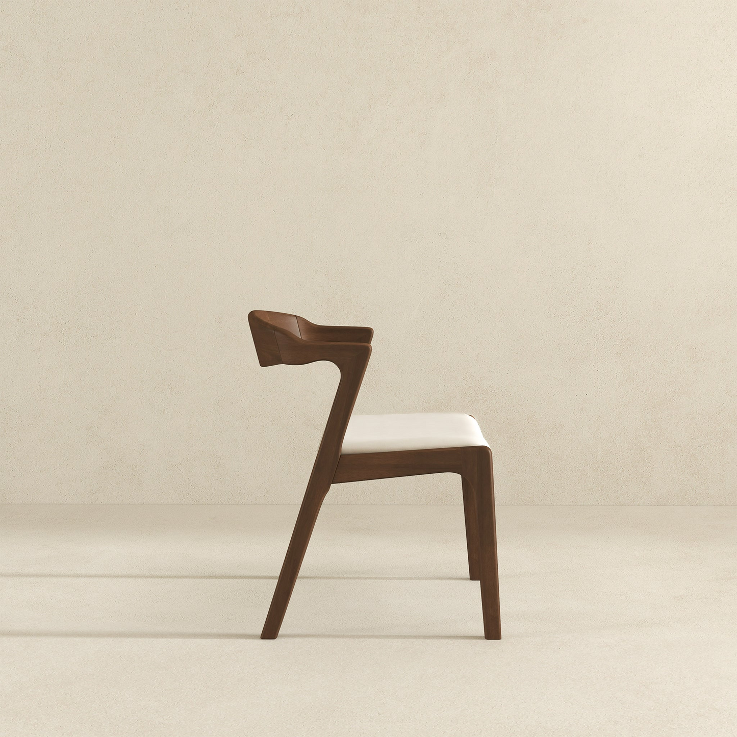 Modern wooden dining chair with white cushion, side view, on neutral background