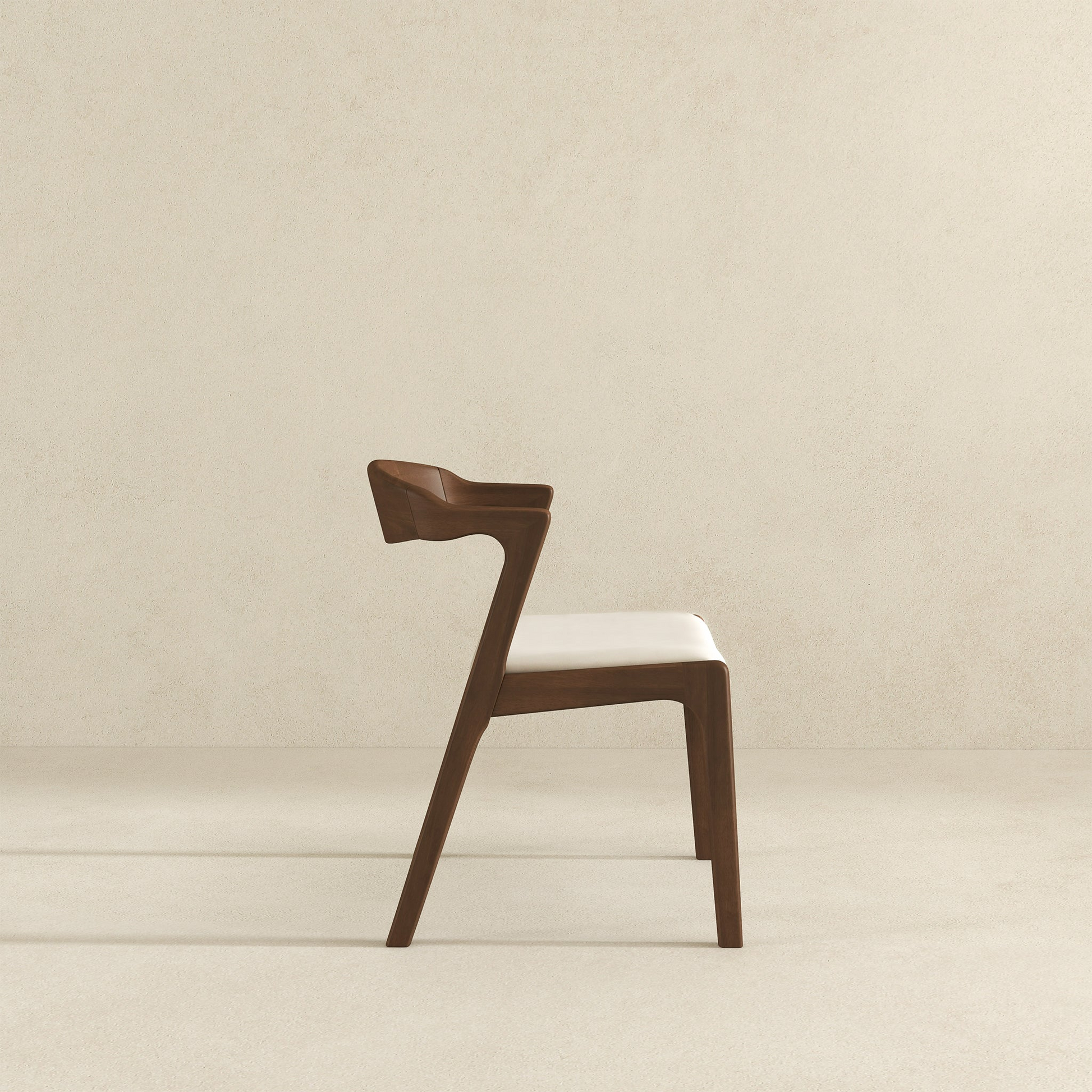 Modern wooden dining chair with white cushion, side view, on neutral background