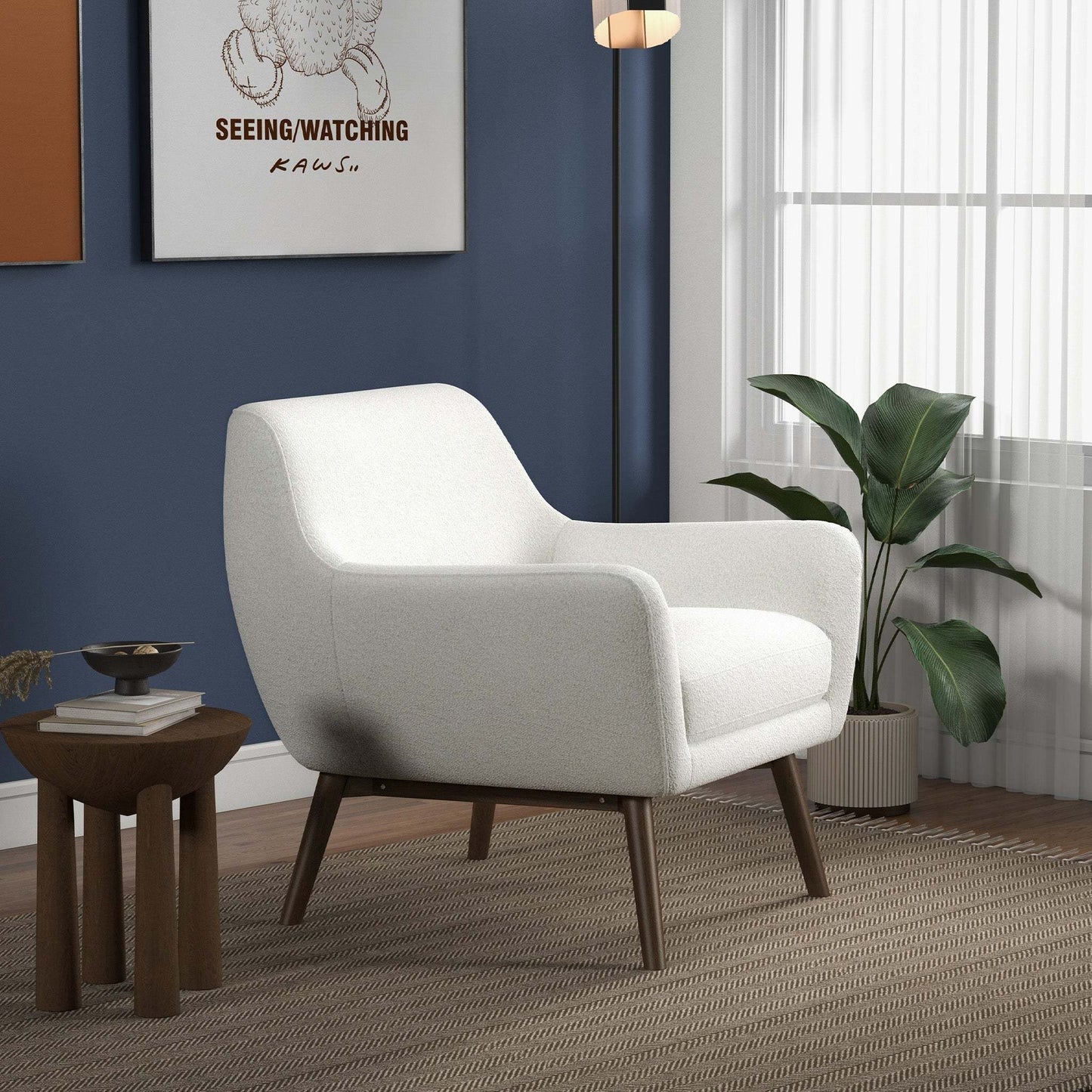 Modern white accent chair in living room with blue wall, houseplant, and wood side table