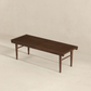 Modern slatted wood bench with tapered legs on minimal beige background, FredCo International furniture