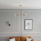 Modern living room with tan sofa, brass chandelier, wall sconce, and Rome map art print