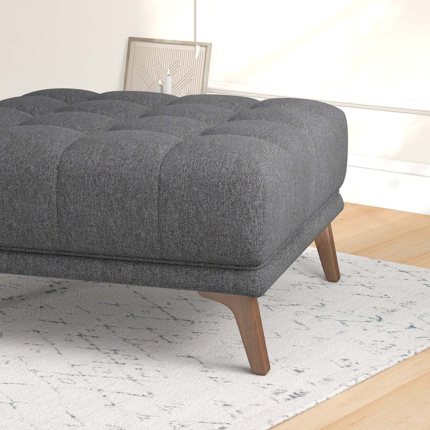 Modern gray tufted ottoman with wooden legs on a patterned rug, FredCo International furniture