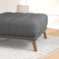 Modern gray tufted ottoman with wooden legs on a patterned rug, FredCo International furniture