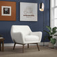 Modern living room with white accent chair, wall art, floor lamp, and indoor plant
