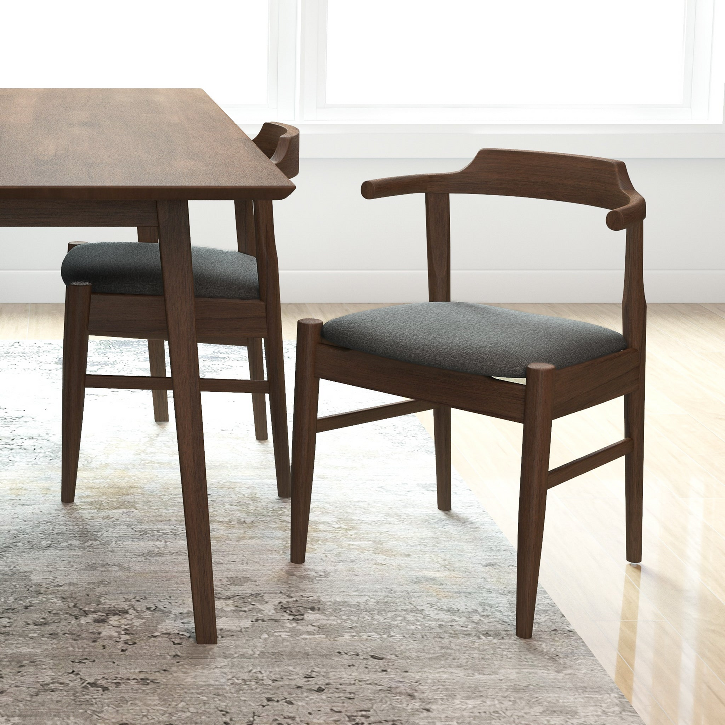 Mid-century modern wood dining chair with dark cushion next to matching table in bright room