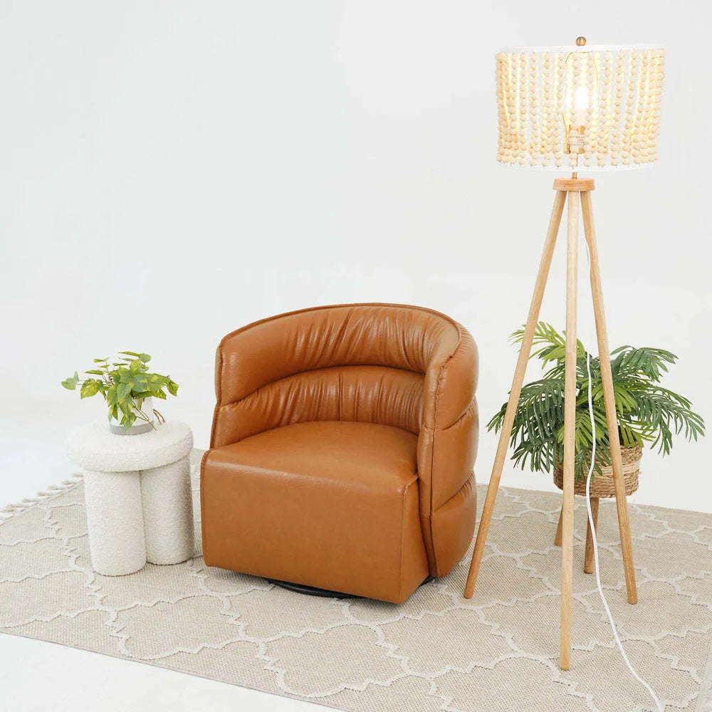 Modern brown leather accent chair with white side table and tripod floor lamp on area rug