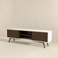 Modern TV stand with white frame, dark wood drawers, and open shelf on angled legs