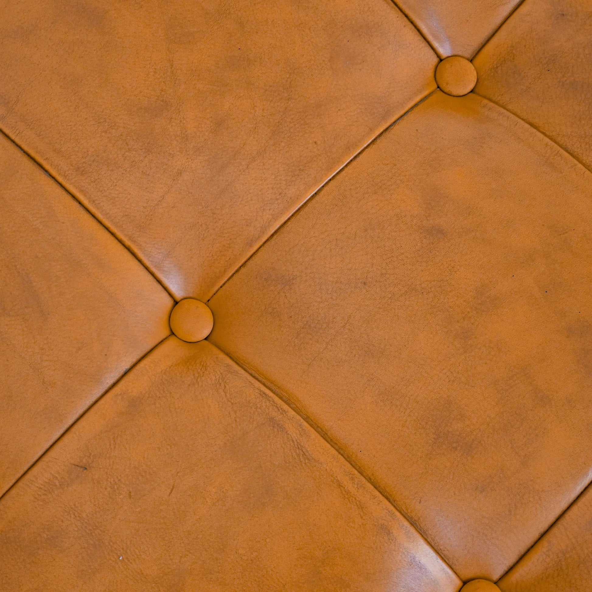 Brown tufted leather upholstery with button details, furniture texture at FredCo International
