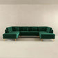 Modern green velvet sectional sofa with tufted cushions and gold legs in minimalist room