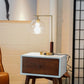 Modern brass table lamp with glass globe on wood nightstand in stylish living room