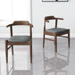 Modern wooden dining chairs with gray cushions in a bright room, FredCo International furniture
