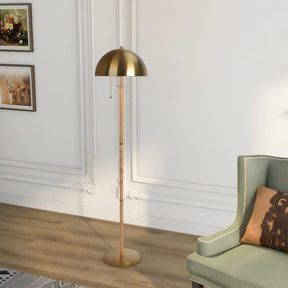 Modern gold floor lamp next to green accent chair in elegant living room, FredCo International furniture