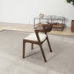 Modern wood accent chair with white cushion on rug in minimalist living room