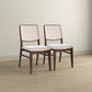 Pair of modern dining chairs with wooden frames and beige upholstery on hardwood floor