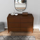 Modern wooden dresser with curved edges, mirror, and minimalist decor in a stylish home