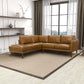 Modern living room with brown leather sectional sofa, large window, and minimalist decor