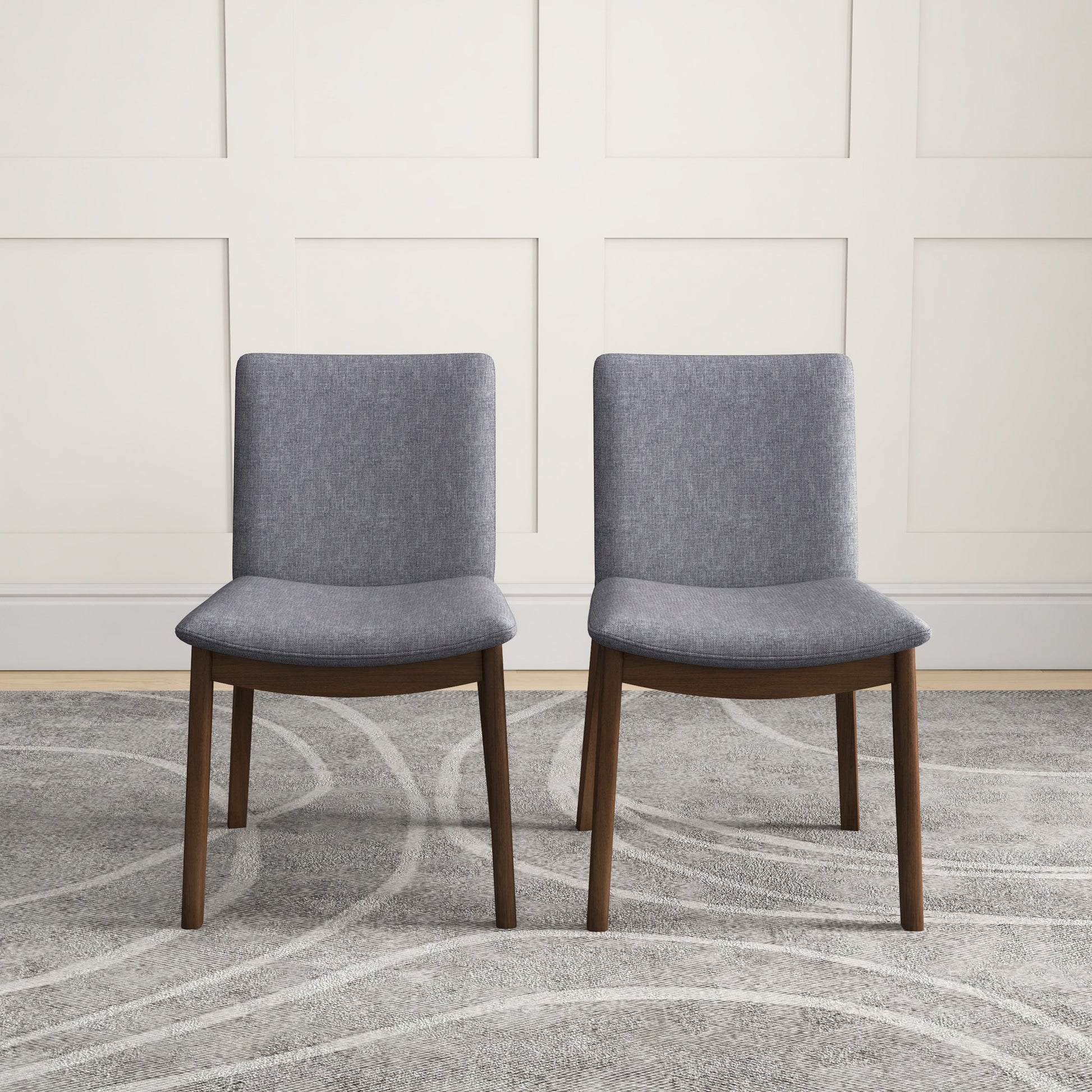 Set of two modern gray upholstered dining chairs with wooden legs on patterned rug