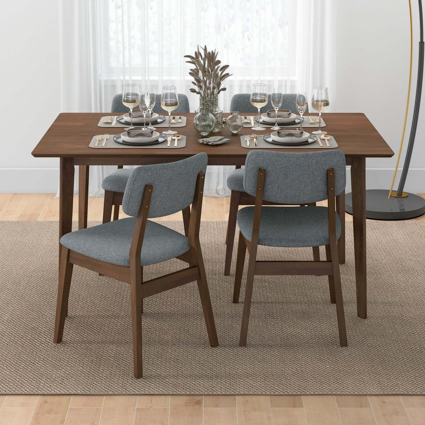 Modern dining room with wooden table, gray chairs, and elegant table setting