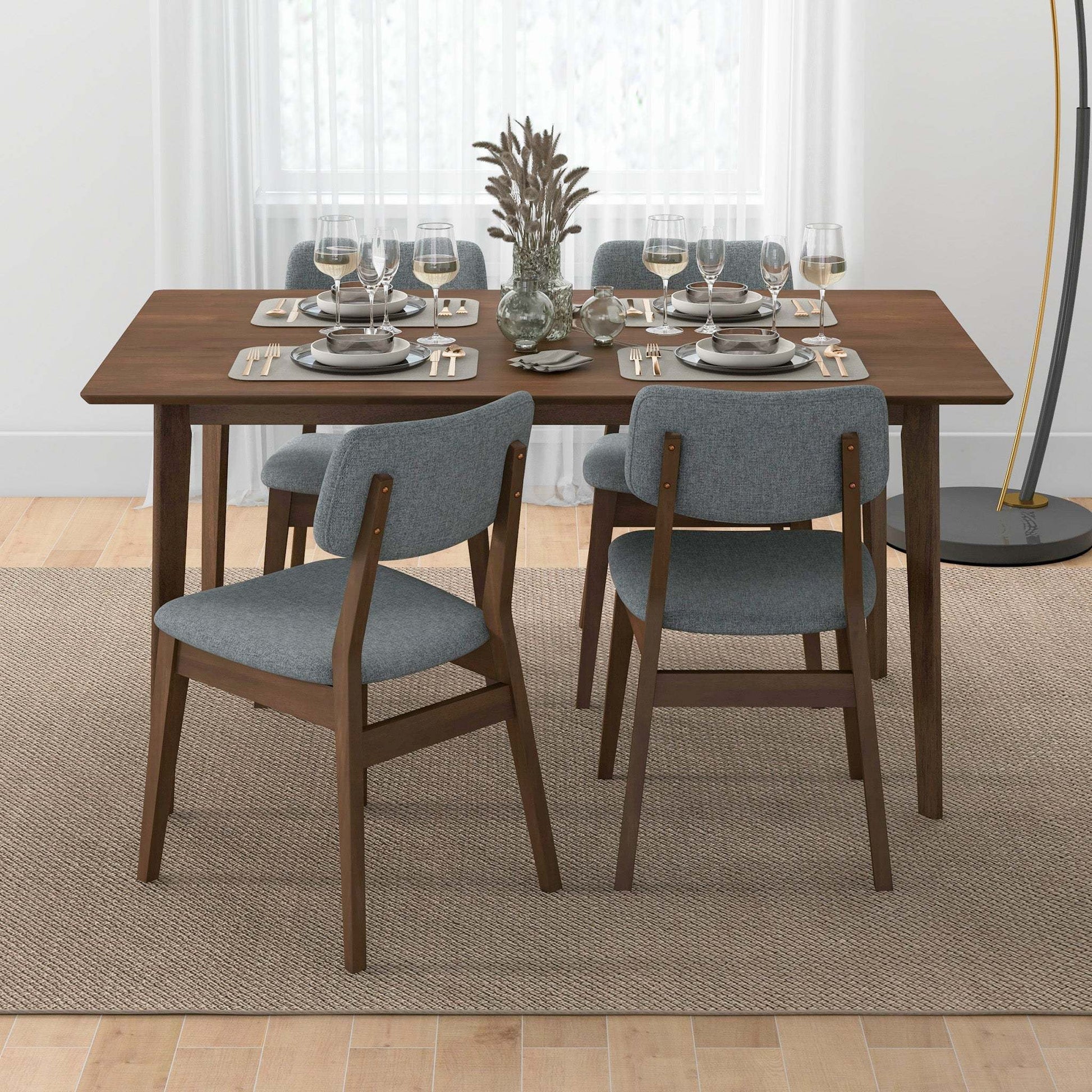 Modern dining room with wooden table, gray chairs, and elegant table setting