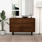 Modern wooden dresser in a stylish living room with decor, artwork, and floor lamp