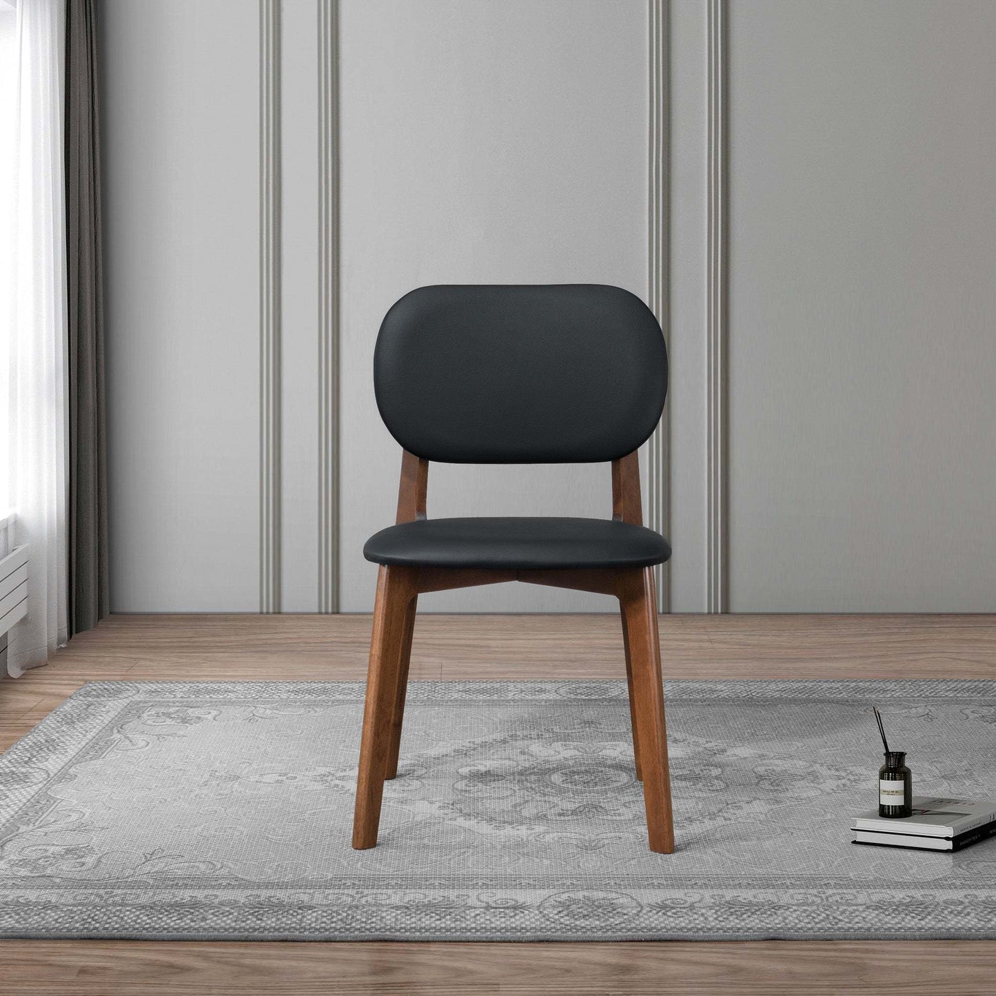Modern black and wood accent chair on gray rug in stylish living room, FredCo International furniture