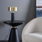 Modern black side table with gold lamp beside a white upholstered chair in a stylish living room
