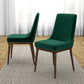 Set of two modern green dining chairs with wooden legs on textured rug in bright room