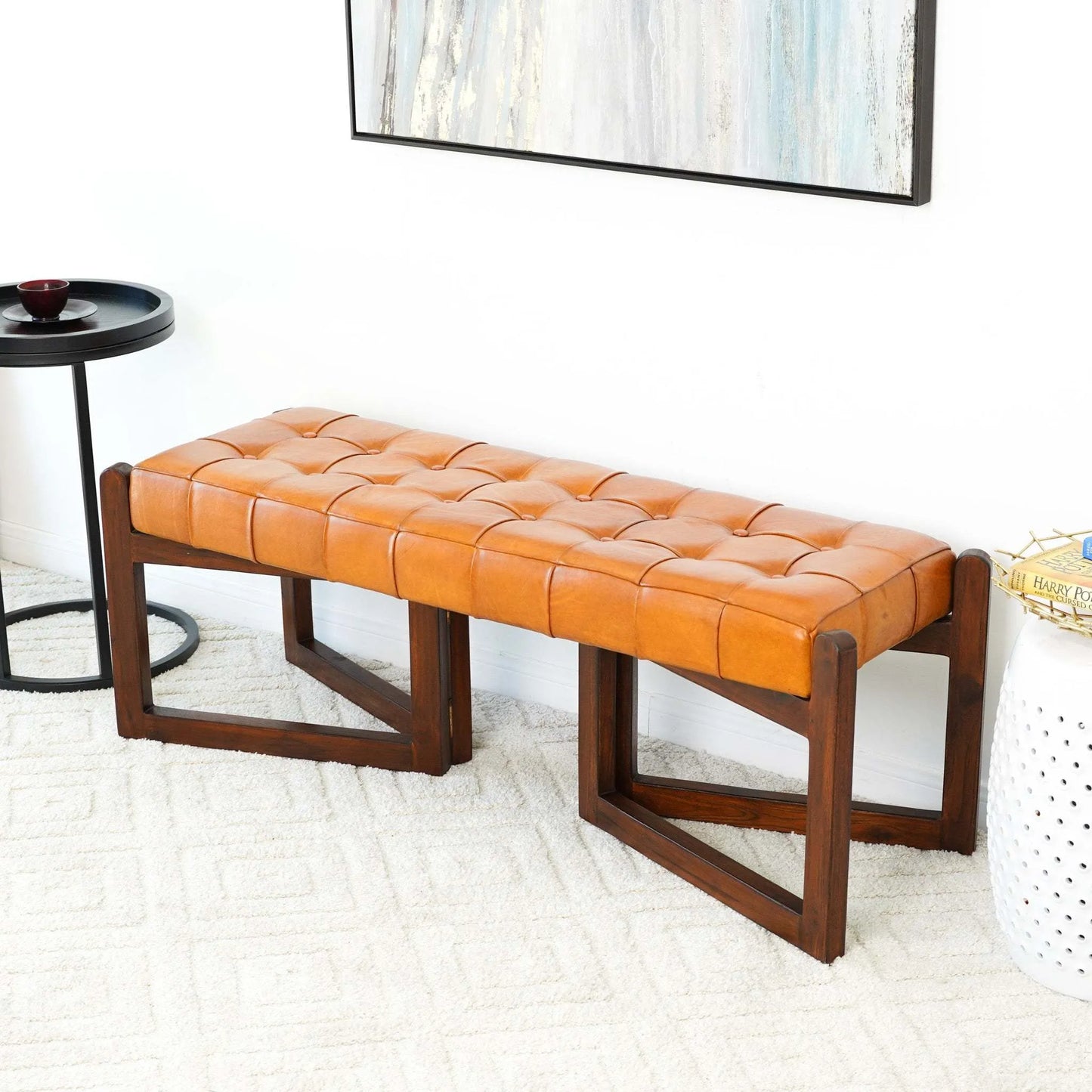 Modern tufted leather bench with dark wood legs in a stylish home setting, FredCo International furniture