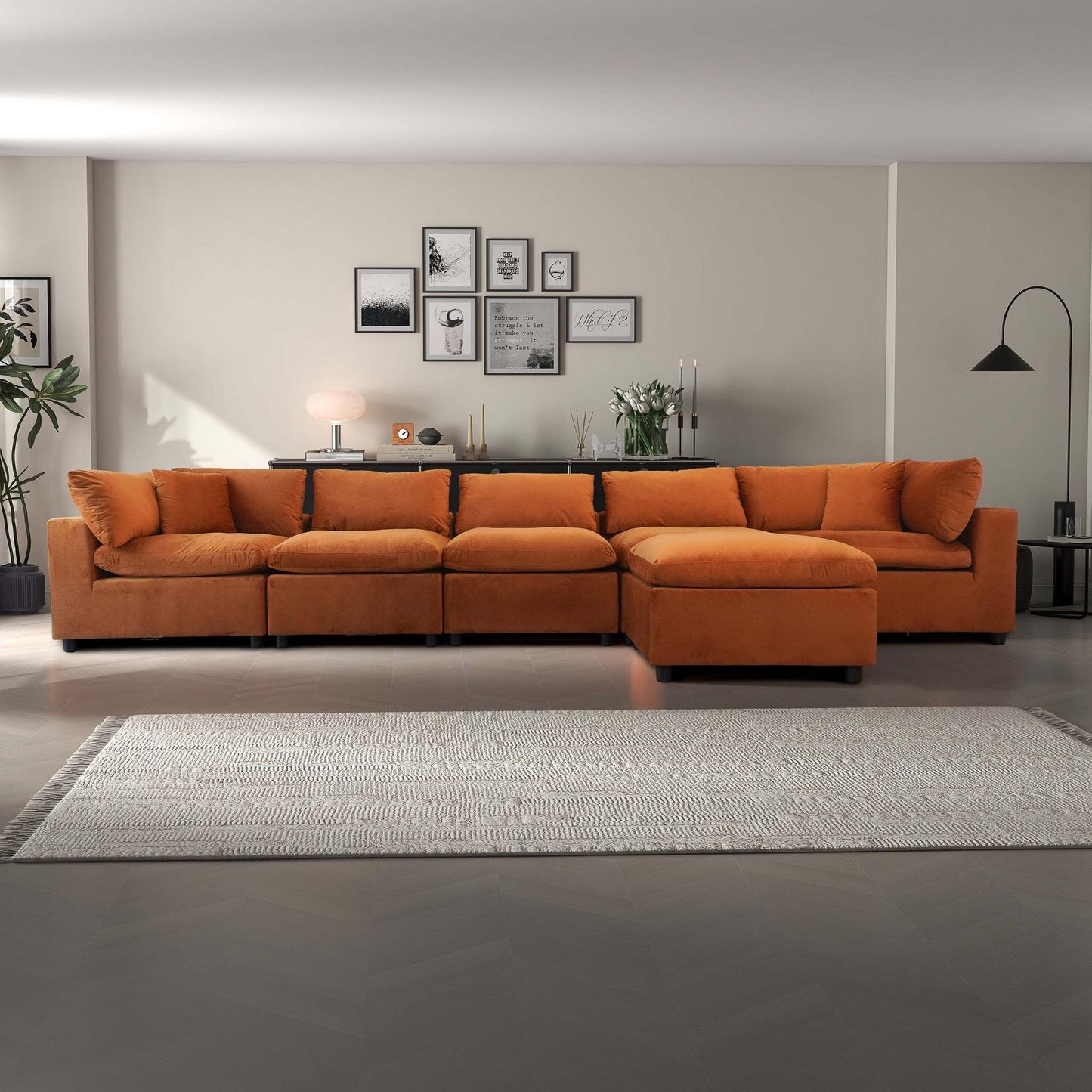 Modern living room with orange sectional sofa, gallery wall, and neutral decor from FredCo International
