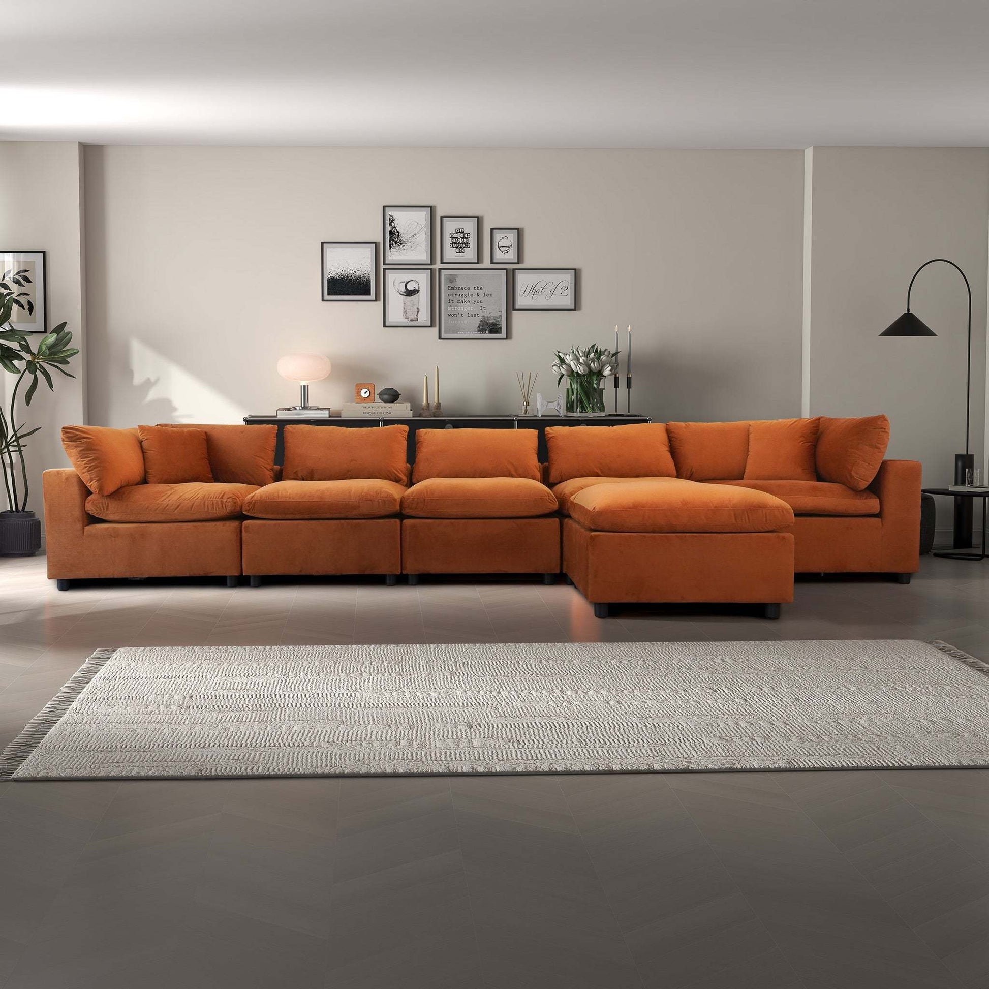 Modern living room with orange sectional sofa, gallery wall, and neutral decor from FredCo International