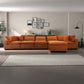 Modern living room with orange sectional sofa, gallery wall, and neutral decor from FredCo International
