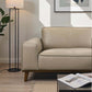 Modern beige leather sofa in a bright living room with floor lamp and coffee table