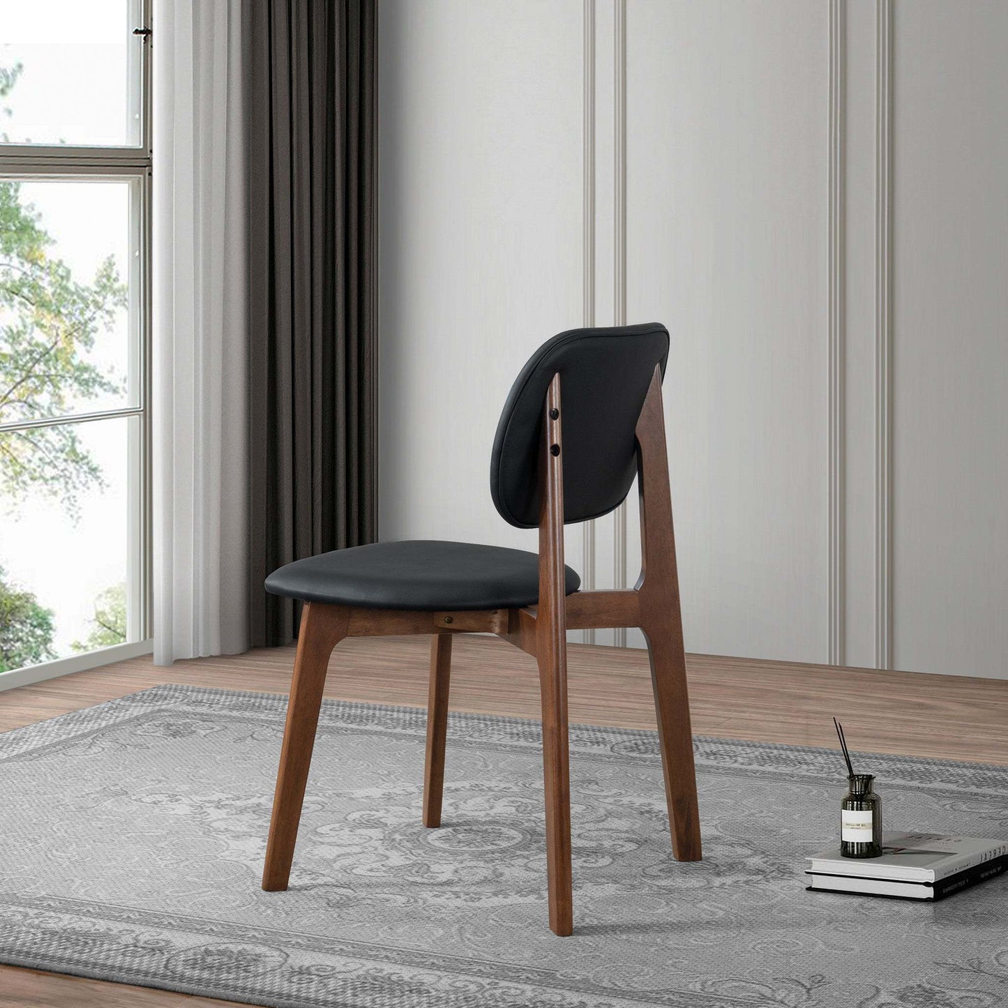 Modern black and wood dining chair on rug in bright living room, FredCo International furniture