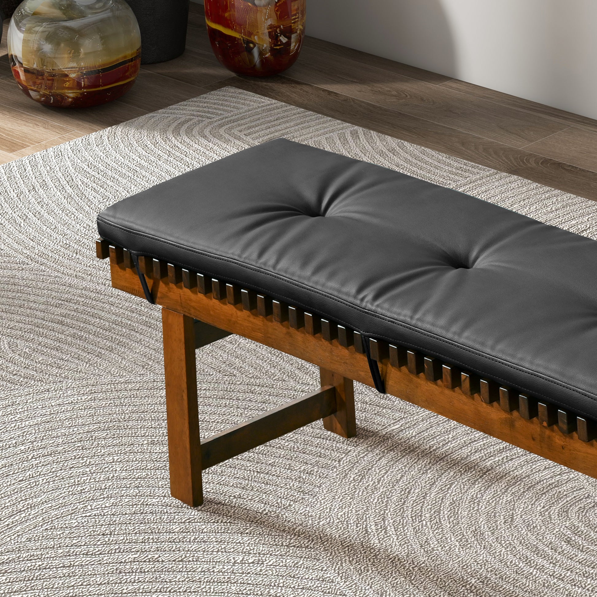 Modern wooden bench with black tufted cushion on textured rug, FredCo International furniture