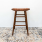 Modern wooden bar stool with woven leather seat on patterned rug, FredCo International furniture