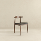 Modern wooden dining chair with dark cushioned seat in minimalist room, FredCo International furniture