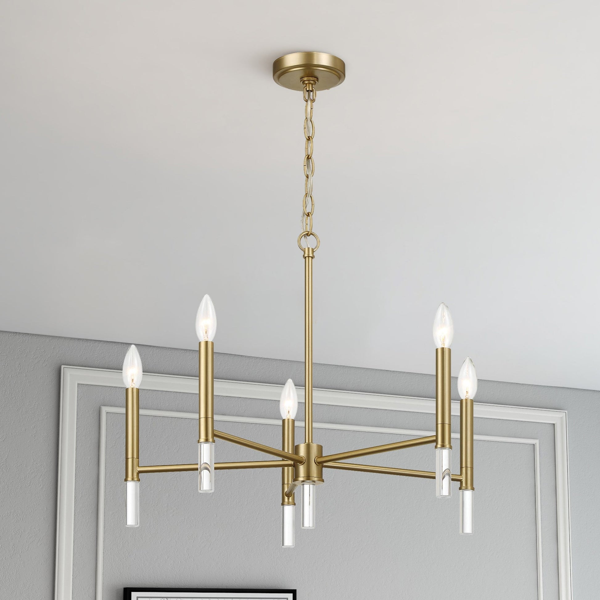 Modern gold chandelier with six candle bulbs in elegant home interior, FredCo International