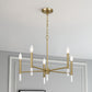 Modern gold chandelier with six candle bulbs in elegant home interior, FredCo International