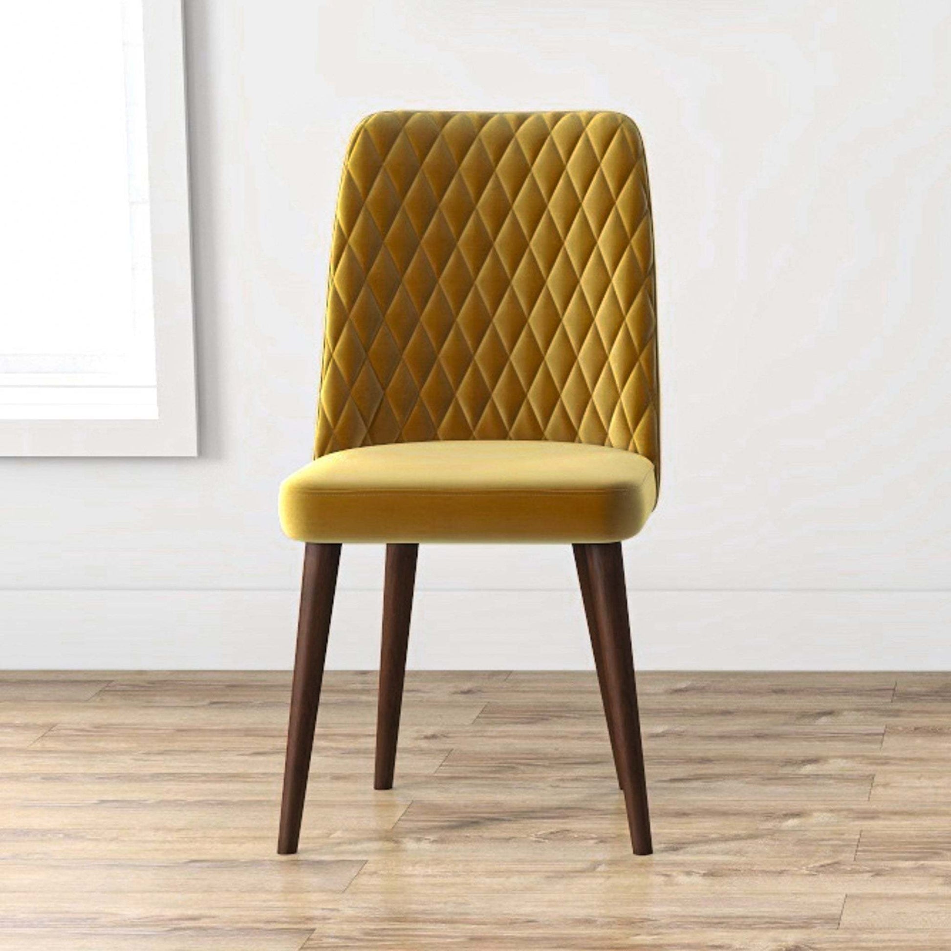 Modern mustard yellow dining chair with quilted back and wooden legs on wood floor