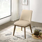 Modern beige upholstered dining chair with wooden legs on a patterned rug in a bright room