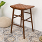 Modern wooden counter stool with woven leather seat on patterned rug, home furniture decor