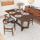 Modern wood dining table set with four chairs, tableware, and decor in a stylish home interior