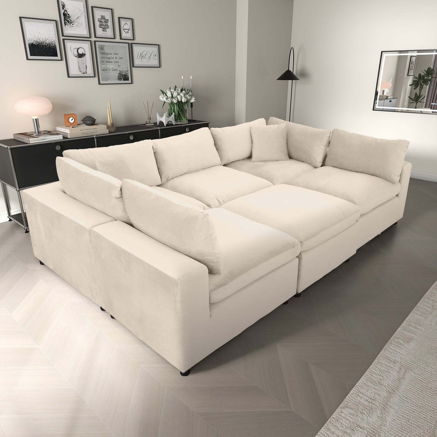Modern living room with a large beige sectional sofa, decorative pillows, and stylish wall art