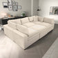 Modern living room with a large beige sectional sofa, decorative pillows, and stylish wall art