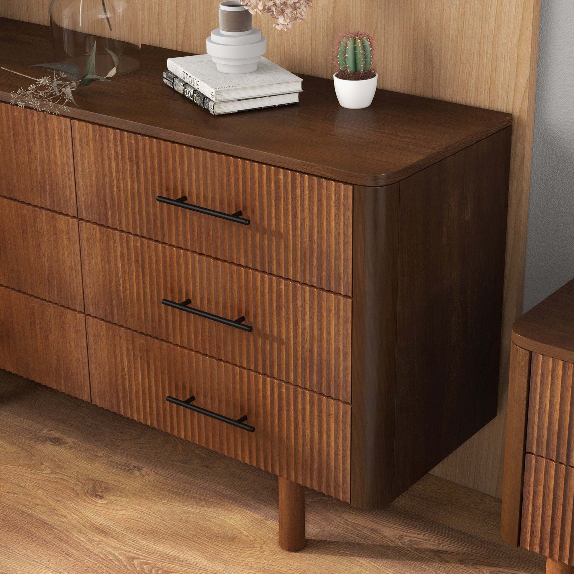 Mid-century modern wood dresser with black handles in a stylish home, FredCo International furniture.