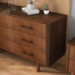 Mid-century modern wood dresser with black handles in a stylish home, FredCo International furniture.
