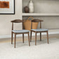 Pair of modern wooden dining chairs with light gray cushions in a stylish home setting
