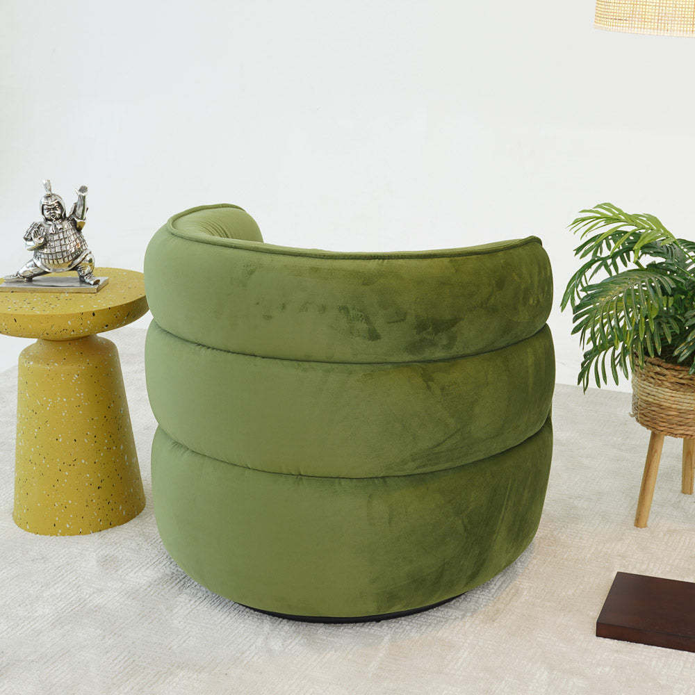 Modern green velvet accent chair with round side table and decorative plant in living room