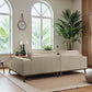 Modern living room with beige sofa, indoor plants, large windows, and natural light at FredCo International.