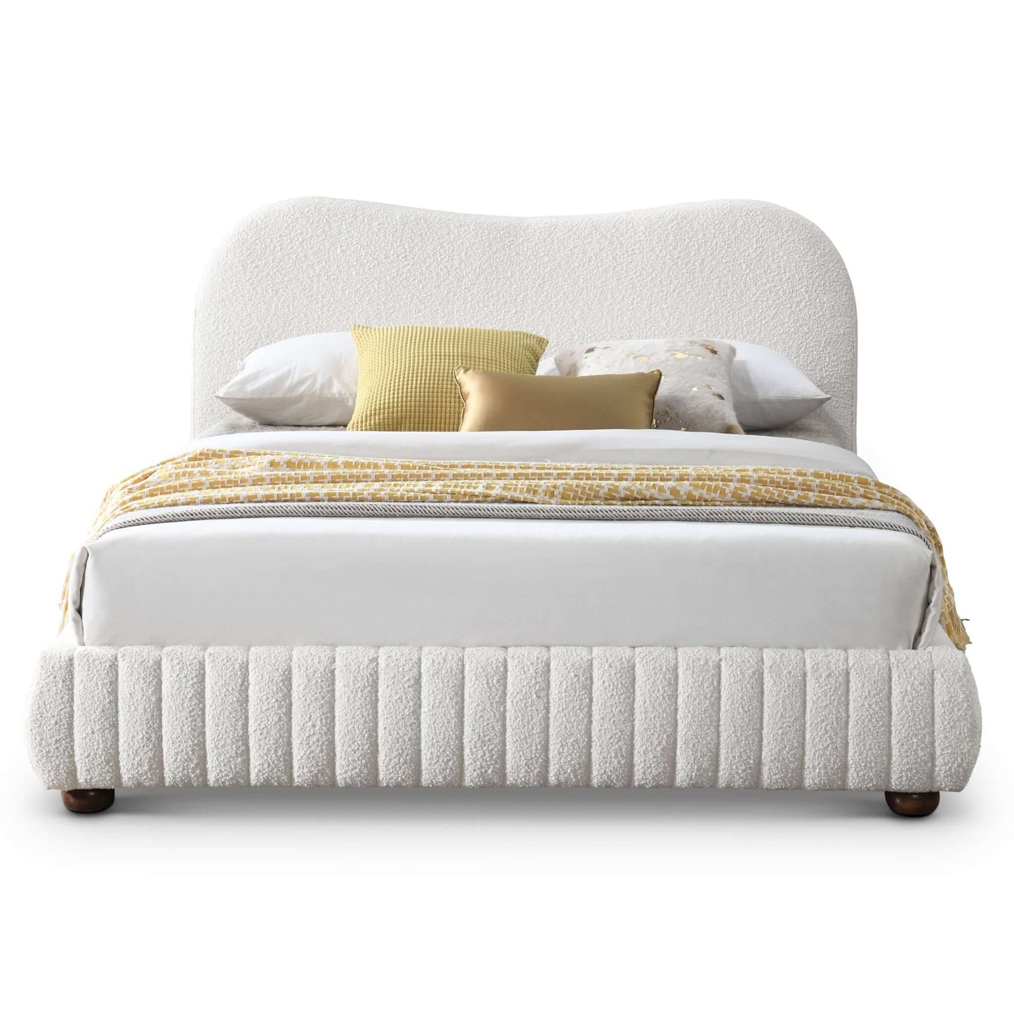 Modern upholstered bed with white textured frame, decorative pillows, and yellow throw blanket